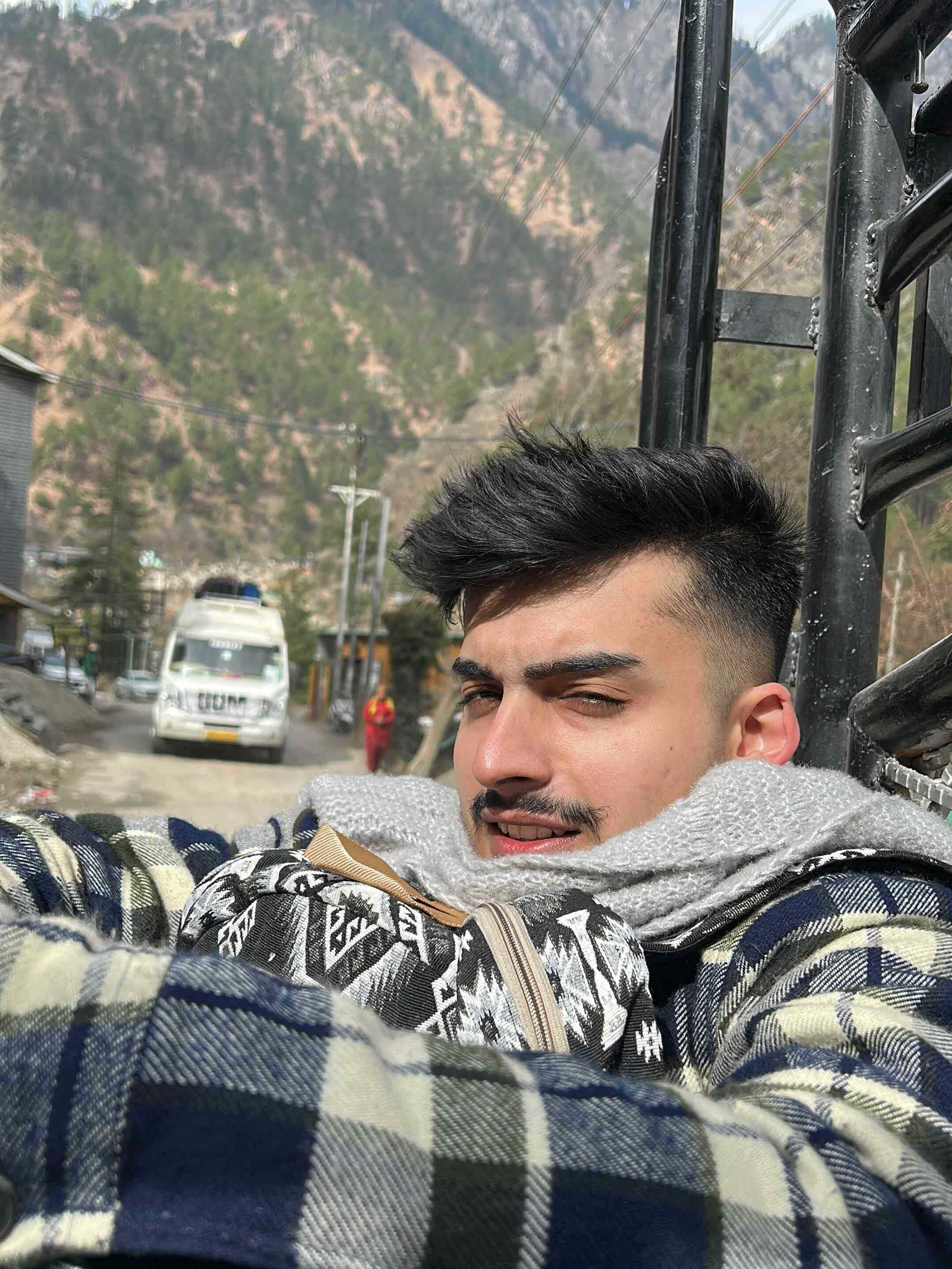 A person in the back of a camper van with mountains in the background